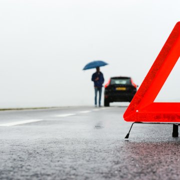 extended car warranty services protect my car car breakdown man with umbrella on the side of the road red triangle